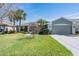 Charming single-story home featuring a well-maintained lawn, mature palm trees, and an attached two-car garage at 10237 Collar Dr, San Antonio, FL 33576