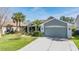 Charming single-story home featuring a well-maintained lawn, mature palm trees, and an attached two-car garage at 10237 Collar Dr, San Antonio, FL 33576