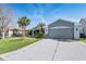 Charming single-story home featuring a well-manicured lawn, palm trees, and a two-car garage at 10237 Collar Dr, San Antonio, FL 33576