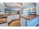 Bright kitchen with white cabinetry, solid surface countertops, and views of the living space at 10237 Collar Dr, San Antonio, FL 33576
