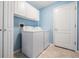 Laundry room with a washer, dryer, white cabinets, and a white door at 10237 Collar Dr, San Antonio, FL 33576