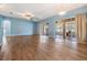 Spacious living room featuring wood floors, blue walls, fan and sliding door leading to the lanai at 10237 Collar Dr, San Antonio, FL 33576