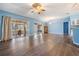 Spacious living room featuring wood floors, blue walls, fan and sliding door leading to the lanai at 10237 Collar Dr, San Antonio, FL 33576