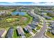 Community aerial view with lakeside homes, lush greenery, walking path, pool and splash pad at 10432 High Noon Trl, Parrish, FL 34219