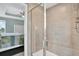 Bathroom shower enclosed in glass with neutral tiling and shower rack at 10432 High Noon Trl, Parrish, FL 34219