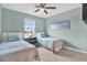 Bedroom with two twin beds, ceiling fan, and a beach-themed art print on the wall at 10432 High Noon Trl, Parrish, FL 34219