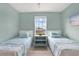 Bedroom features two twin beds and a window that provides ample natural light at 10432 High Noon Trl, Parrish, FL 34219
