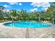 Inviting community pool surrounded by lounge chairs, palm trees and lush landscaping offers a perfect spot for relaxation at 10432 High Noon Trl, Parrish, FL 34219