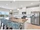 Kitchen island featuring a stainless steel sink, granite counters, pendant lights, and barstool seating at 10432 High Noon Trl, Parrish, FL 34219