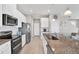 Kitchen featuring granite counters, stainless steel appliances, an island, and white cabinetry at 10432 High Noon Trl, Parrish, FL 34219