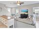 Open living room featuring a plush sectional sofa, ceiling fan, and mounted television at 10432 High Noon Trl, Parrish, FL 34219