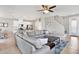 Bright and airy living room with a large sectional, tile floors, open to the kitchen and dining area at 10432 High Noon Trl, Parrish, FL 34219