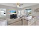 Comfortable living room with a large sectional, TV, ceiling fan and view of the backyard and pool at 10432 High Noon Trl, Parrish, FL 34219