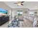 Cozy living room with a large sectional, TV, and sliding glass doors leading to the backyard at 10432 High Noon Trl, Parrish, FL 34219