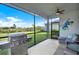 Relax on this screened patio complete with a grill, ceiling fan, and a view of the backyard at 10432 High Noon Trl, Parrish, FL 34219