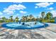 Community splash pad with various water features, set against a backdrop of blue skies and palm trees at 10432 High Noon Trl, Parrish, FL 34219