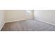 A simple bedroom with light walls, carpet flooring and a single window at 11549 Tangle Branch Ln, Gibsonton, FL 33534