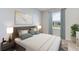Cozy bedroom with a large window, neutral decor, and stylish lamps at 12059 Kingsley Trl, Parrish, FL 34219