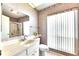 Bright bathroom featuring white cabinets, a large mirror, and walk-in shower at 1504 Valley Forge Blvd, Sun City Center, FL 33573