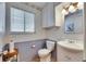 Bathroom features a toilet, vanity with sink, medicine cabinet, and wallpapered walls at 1504 Valley Forge Blvd, Sun City Center, FL 33573