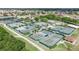 Aerial view of tennis courts, with blue canopies, surrounded by lush green landscaping at 1504 Valley Forge Blvd, Sun City Center, FL 33573
