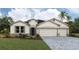 Charming single-story home with stone accents, manicured lawn, and a spacious three-car garage at 17130 James Trl, Parrish, FL 34219
