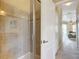 Bathroom featuring a glass-enclosed shower with decorative tiles, a hall, and a bedroom at 19724 Fort King Run, Brooksville, FL 34601