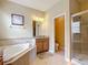 Bathroom featuring a large tub, double sink vanity, and a glass-enclosed shower at 19724 Fort King Run, Brooksville, FL 34601