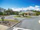 View of clubhouse with American flag, mature landscaping, and easy traffic flow at 19724 Fort King Run, Brooksville, FL 34601