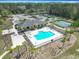 Aerial view showcasing the sparkling community pool with ample seating and a clubhouse nearby at 19724 Fort King Run, Brooksville, FL 34601