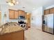 The bright kitchen with stainless steel appliances, granite countertops, and tile flooring at 19724 Fort King Run, Brooksville, FL 34601