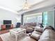 Bright living room with hardwood floors, a ceiling fan, and sliding glass doors to the lanai at 19724 Fort King Run, Brooksville, FL 34601