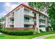 Low angle view of condo building showing balcony views, red trimming, and meticulous landscaping at 2630 Pearce Dr # 107, Clearwater, FL 33764