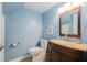 Well-lit bathroom featuring a wooden vanity, neutral countertop, and complemented by light blue walls at 2934 Lichen Ln # C, Clearwater, FL 33760