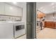 Convenient laundry area with modern washer and dryer, storage cabinets, and adjacent kitchen at 2934 Lichen Ln # C, Clearwater, FL 33760