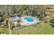 Aerial view of the community pool featuring a unique shape, covered seating, and surrounded by lounge chairs in a fenced in area at 2934 Lichen Ln # C, Clearwater, FL 33760