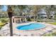 Community pool featuring a unique shape, covered seating, and surrounded by lounge chairs in a fenced in area at 2934 Lichen Ln # C, Clearwater, FL 33760
