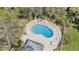 Aerial view of the community pool featuring a unique shape, surrounded by lounge chairs in a fenced in area at 2934 Lichen Ln # C, Clearwater, FL 33760