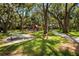 Community playground with mature trees, benches, and a winding walking path at 3600 42Nd S St # 52B, St Petersburg, FL 33711