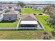 Aerial view of a home with a screened-in lanai and a fenced backyard near a pond at 36419 Flats St, Zephyrhills, FL 33541