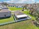 Aerial view of a home with a fenced yard and screened-in lanai near a pond at 36419 Flats St, Zephyrhills, FL 33541