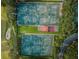 Bird's-eye view of tennis courts nestled in a green landscape with golfers on the adjacent course at 36750 Us Highway 19 N # 6-214, Palm Harbor, FL 34684