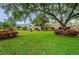 View of a well-manicured community with lush lawns, walkway, and mature trees surrounding the residential buildings at 36750 Us Highway 19 N # 6-214, Palm Harbor, FL 34684