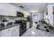 Renovated kitchen with stainless steel appliances, white cabinetry, stylish backsplash, and granite counters, bright with plenty of natural light at 36750 Us Highway 19 N # 6-214, Palm Harbor, FL 34684