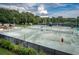 A lively tennis court complex with several courts, people playing, and shaded rest areas at 36750 Us Highway 19 N # 6-214, Palm Harbor, FL 34684