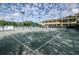 Outdoor tennis court with well-maintained surface, net, and seating with view of Innisbrook Tennis Center building at 36750 Us Highway 19 N # 6-214, Palm Harbor, FL 34684