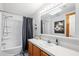 Bathroom featuring wood vanity, tub/shower, skylight, and large mirror with vanity lighting at 36838 Tara Ave, Zephyrhills, FL 33542