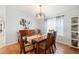 This dining room features a wood table, six chairs, a buffet, and a hanging light fixture at 36838 Tara Ave, Zephyrhills, FL 33542