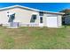 Home exterior with a well-maintained lawn, light-colored siding, and an attached single-car garage with a white door at 36838 Tara Ave, Zephyrhills, FL 33542