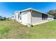 Home exterior showing the garage and the screened-in patio, and an air conditioning unit at 36838 Tara Ave, Zephyrhills, FL 33542